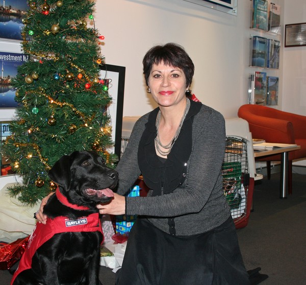 Bayleys Wellington residential sales manager Babette Newman and guide dog PJ stack up the goodies going on auction for the Royal New Zealand Foundation of the Blind's Guide Dog Services 
